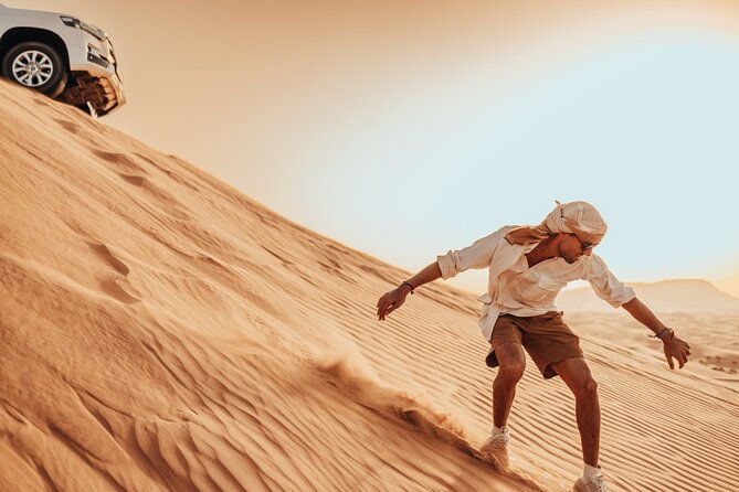 Deluxe Sunset Desert Safari: SandSurfing, Camel Ride & BBQ dinner - Sandboarding at sunset